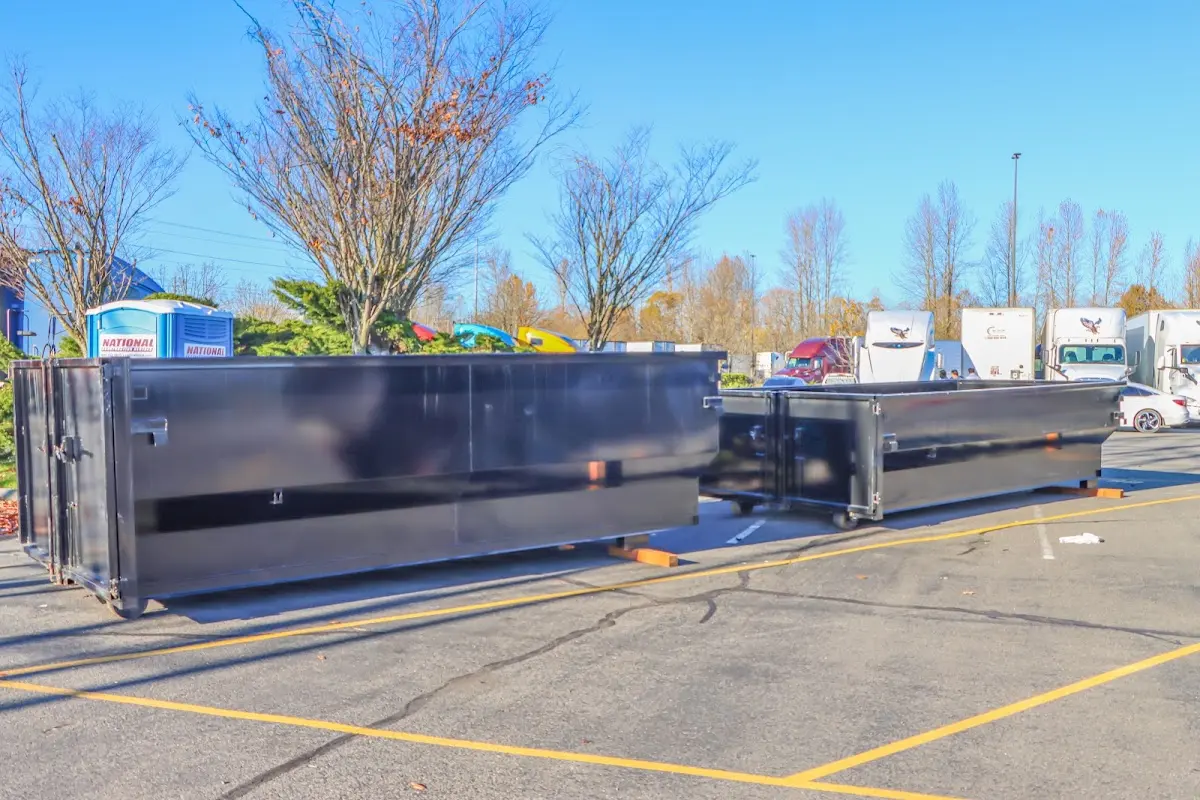 Professional dumpster rental service with roll-off container on residential driveway in Cadillac